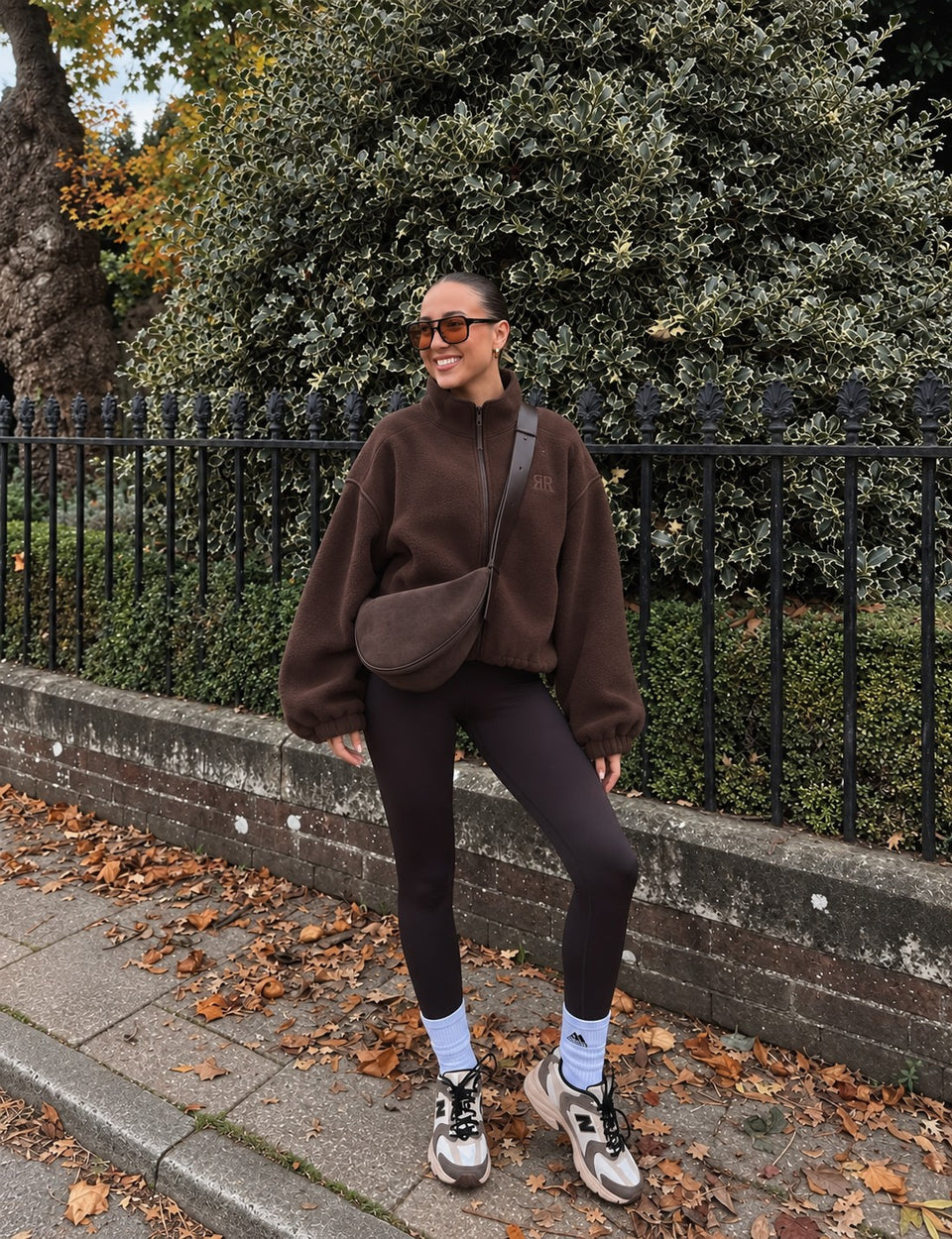 Mujer con la Chaqueta Era café, leggings y tenis en la calle